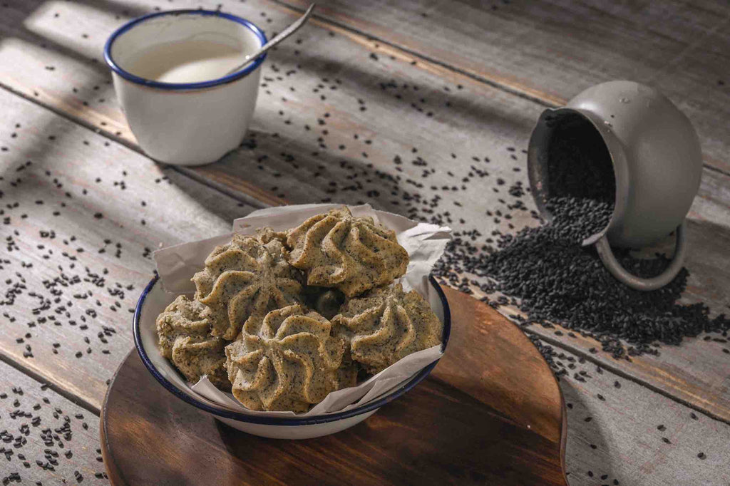Lowrey Black Sesame butter cookies on a wooden board with sesame seeds