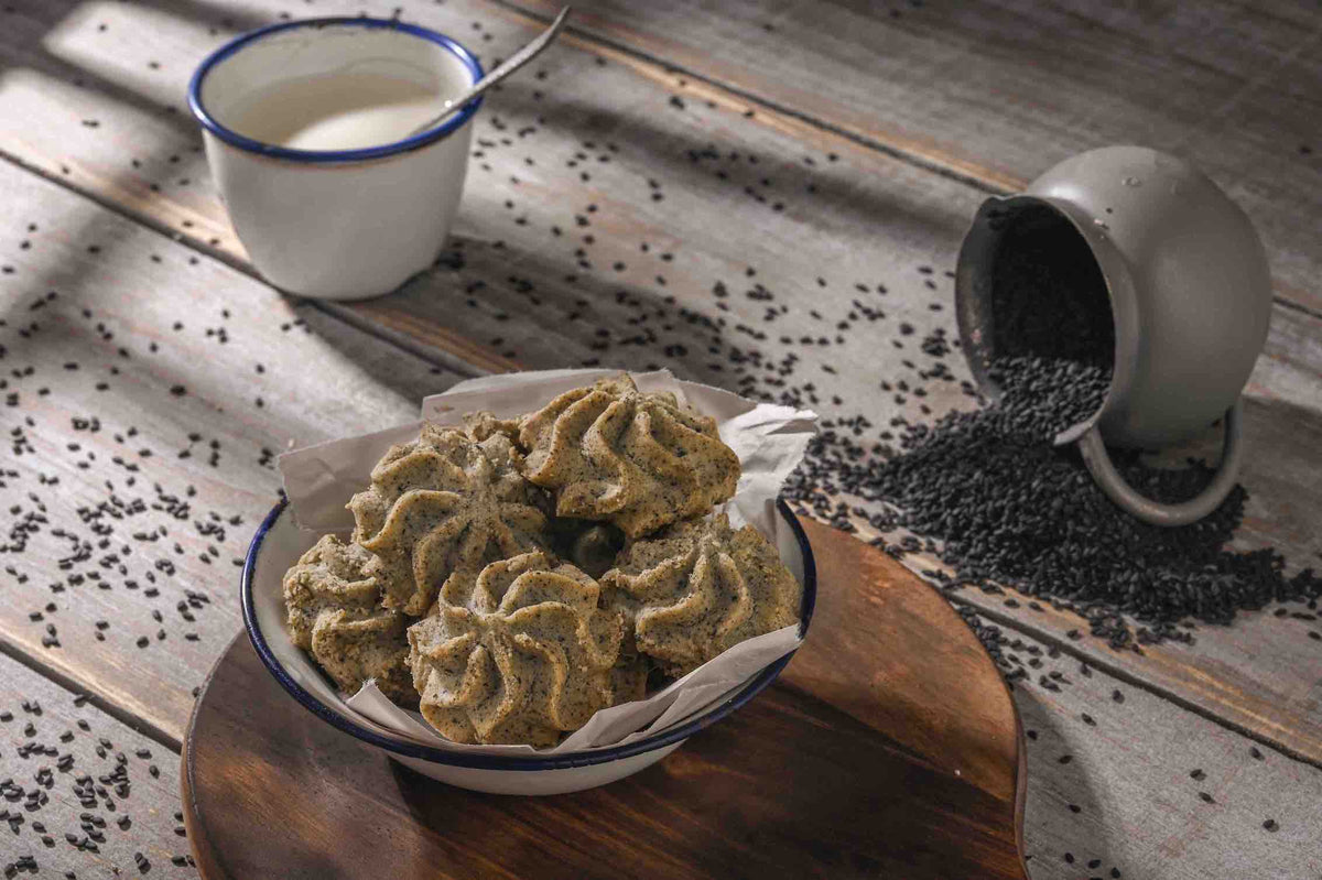 Lowrey Black Sesame butter cookies on a wooden board with sesame seeds