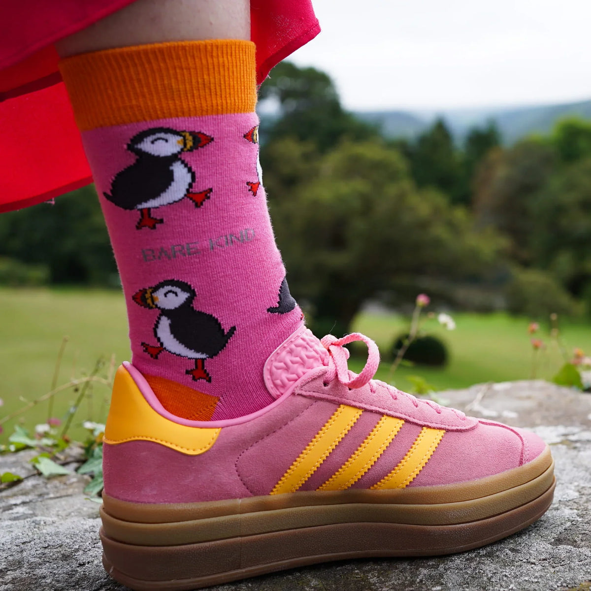 Person wearing pink Barekind puffin socks with pink sneakers