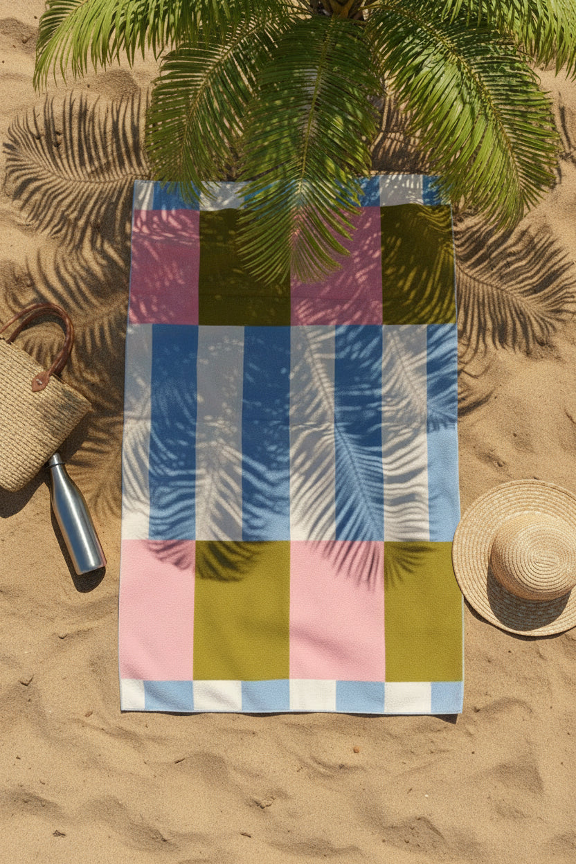 Pink, green and blue Frankly Cotton beach towel on the sand under palm shade